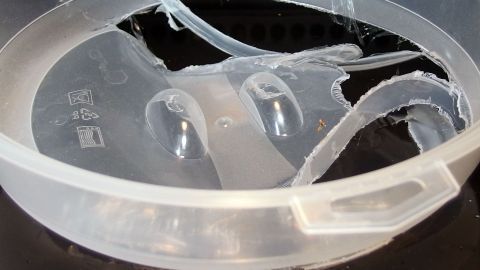 Ein beschädigter, geschmolzener Plastikdeckel liegt auf einem Glaskeramikfeld und lässt Rückstände hinter.