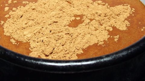 Zimt ist abgesehen von seiner starken Duftwirkung auch sehr wirksam gegen Bakterien und Pilze und nach dieser "Behandlung" ist das Raumklima deutlich besser. Ein dunkelbrauner Behälter zeigt ein feines, teilweise verstreutes, goldenes Pulver, das möglicherweise als Raumduft mit desinfizierender Wirkung dient.