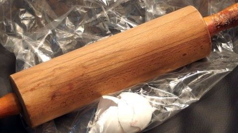 Ein Holzroller liegt auf Plastikfolie neben zerbröselten Eierschalen, die zum Düngen verwendet werden sollen.