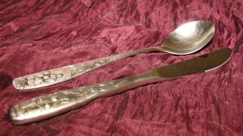 Elegantes Silberbesteck liegt auf einem weichen, roten Stoff und wartet darauf, leicht eingeölt und verstaut zu werden.