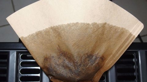 Ein Kaffeefilter liegt auf einem Heizkörper, während er die trockene Heizungsluft absorbiert, um Schimmel zu vermeiden.