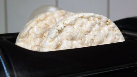Reiswaffeln werden im Toaster erhitzt und nehmen dabei eine knusprige Form an. Hintergrund ist eine moderne Küche.