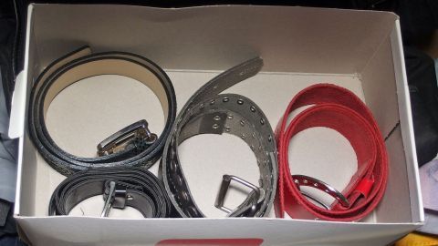 Schuhkarton im Kleiderschrank enthält ordentlich gefaltete Gürtel in verschiedenen Farben und Materialien für gute Ordnung.