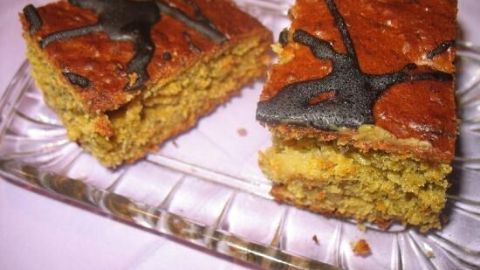 Saftiger Ananas-Möhrenkuchen liegt auf einem Glasplatten, die Stücke sind frisch geschnitten und appetitlich angerichtet.