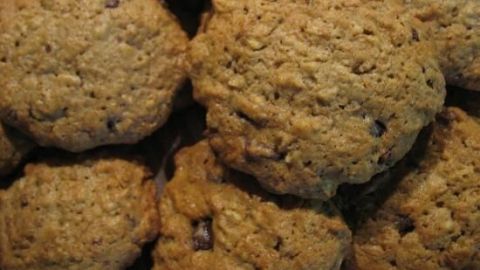 Runde Haferflocken-Apfel-Cookies liegen übereinander, frisch gebacken, mit leicht goldbrauner Farbe und knuspriger Textur.