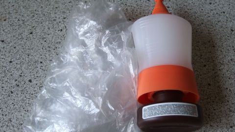 Eine durchsichtige Flasche steht neben transparentem Plastik, ideal zum Haare tönen mit wiederverwendbaren Obsttüten.