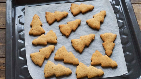 Plätzchen für den Tortenboden verwenden - eine Resteverwertung für Gebäck. Plätzchen in Tannenbaumform liegen auf einem Backblech, bereit zur Verwendung für einen Tortenboden in einer gemütlichen Küche.