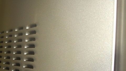 Eine glänzende Edelstahloberfläche wird gereinigt, um die matte und gebürstete Struktur sichtbar zu machen.