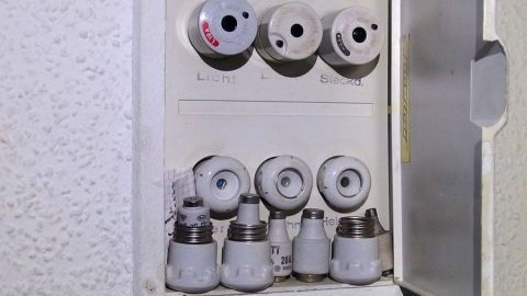 Ein Tipp zum Schmunzeln: Essen ohne kochen zu müssen. Eine Reihe von Glühbirnen sitzt in einem weißen Schalterkasten, bereit zum Einsatz in einem Wohnraum ohne Kochen.