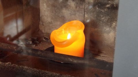 Ein leuchtender Kerzenhalter steht im Kamin, der eine gemütliche Atmosphäre im Wohnraum schafft.