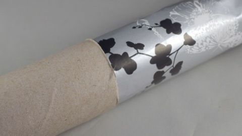 Eine Geschenkpapierrolle wird durch eine Küchenpapierrolle geschützt, die als Lagerungsstütze dient.