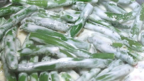 Rohe Bohnen enthalten einen giftigen Eiweißstoff. Man sollte sie nie roh essen! Grüne Bohnen liegen in einer weißen, cremigen Sauce und sind zubereitet, um die Gefahren von rohen Bohnen zu vermeiden.