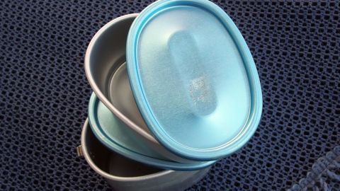 Eine gestapelte Bento Box in sanften Blau-Tönen ruht auf einem strukturierten, dunkelblauen Untergrund.