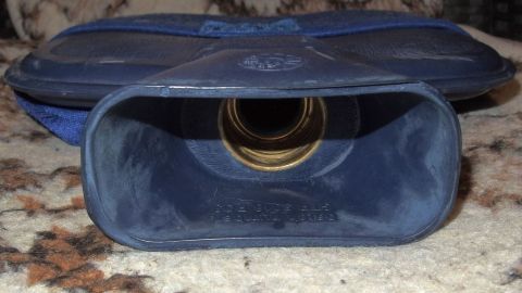 Eine blaue Wärmflasche liegt auf einem Teppich, geöffnet, bereit zum Befüllen mit heißem Wasser für entspannende Wärme.