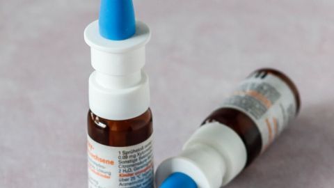 Ein Nasenspray steht bereit, um gegen Nasenbluten eingesetzt zu werden, auf einem sanften Untergrund platziert.