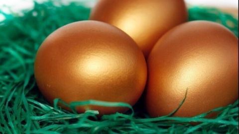 Drei hübsche braune Ostereier liegen in einem Nest aus grünem Gras, das die festliche Osteratmosphäre unterstreicht.
