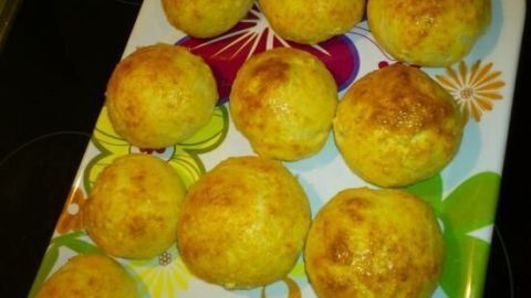 Kleine, goldbraune Brötchen liegen auf einem bunten Tablett und verleihen dem Frühstücksonntag ein frisches Flair.