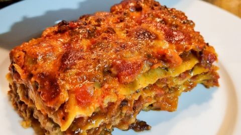 Eine appetitliche Gemüselasagne liegt auf einem weißen Teller, greift das leidenschaftliche Kochen in einer warmen Küchentextur auf.