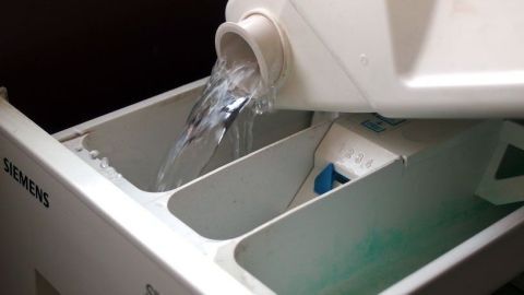 Mit dem Kondenswasser vom Trockner beim Waschen Wasser sparen. Der Tipp zeigt dir, wie es geht. Ein Wassertank des Trockners gibt frisches Kondenswasser ab, während er in einem Waschraum steht.