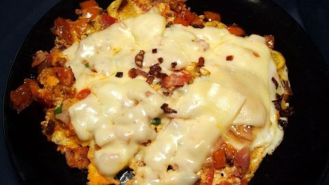 Ein Teller mit köstlicher Lasagne, überbacken mit geschmolzenem Käse, serviert in einer dunklen Umgebung.