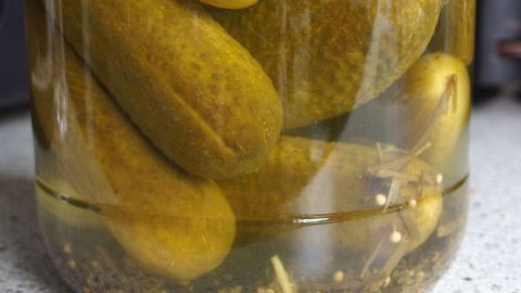 Eingelegtes Gemüse liegt in einem Glas gefüllt mit Essiglösung. Es wirkt erfrischend und kann eine Katerhilfe bieten.