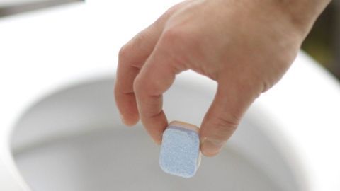 Toilette reinigen mithilfe von Geschirrreiniger-Tabs: Funktioniert wunderbar, Rückstände werden sehr gut entfernt. Ein Hand hält eine Geschirrreiniger-Tab über eine Toilette, bereit, ihn zur Reinigung ins Wasser zu werfen.