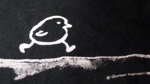 Ein schwarzes T-Shirt mit einem weißen, laufenden Vogel-Logo auf der Vorderseite in einem einfachen, humorvollen Design.