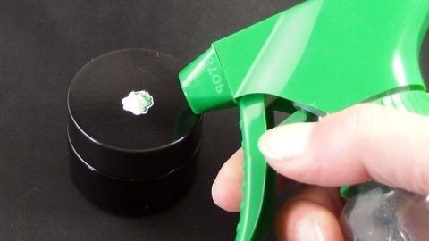 Klebeetiketten mit 1-2 Tropfen Glasreiniger (Sidolin o.ä.) beträufeln, 3-4 Minuten einwirken lassen und mit Glasschaber abziehen. Eine grüne Sprühflasche wird benutzt, um Klebeetiketten von einer dunklen Oberfläche zu entfernen, eventuell Glas oder Plastik.