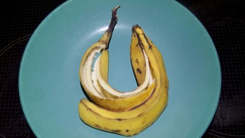 Mit diesem Tipp einer älteren Dame vermeidet ihr Wasserränder an euren Schuhen: Die Schuhe erstmal normal putzen, trocknen lassen und danach mit der Innenseite einer Bananenschale abreiben. Auf einem blauen Teller liegen mehrere Bananen, die darauf warten, Wasserflecken am Schuh zu verhindern.