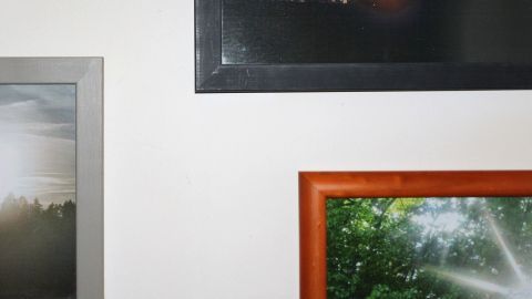 Mehrere Bilder in verschiedenen Rahmen hängen an einer hellen Wand, ohne dass sie verrutschen, dank Radiergummi-Resten.