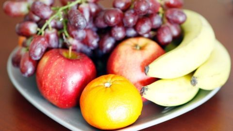 Ein Herz-fruchtiger Obstteller zeigt gekochte Trauben, Äpfel und Bananen, die zur Schnapsherstellung genutzt werden könnten.
