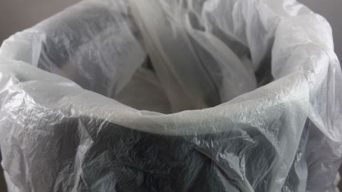 Weiterverwenden von Obst- und Gemüsebeuteln im Kosmetikeimer. Ein transparenter Obst- und Gemüsebeutel ist im Kosmetikeimer platziert, bereit zur Wiederverwendung für Abfälle.