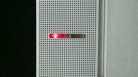 Ein Stromspargerät zeigt ein rotes Licht an, was auf Stand-By-Verluste hinweist, während es an der Wand montiert ist.