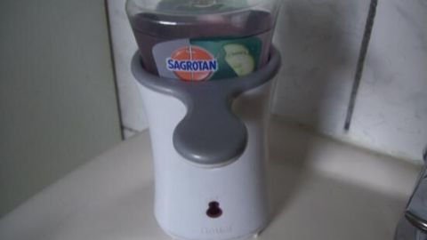 Seifenspender gibt Seife in Badezimmer ab; enthält lila Nachfüllung von SAGROTAN.