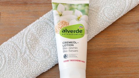 Eine Tube mit alverde Körpercreme steht auf einem Badetuch und bietet Pflege als Effekt eines Single-Lebensstils.