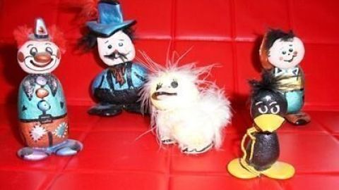 Bunte Steinmännchen stehen auf rotem Hintergrund, fröhlich zusammen, waren kreativ gebastelt und zeigen unterschiedliche Figuren.