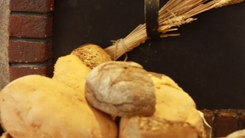 Frisches, selbst gebackenes Brot liegt auf einem Holzbrett, umgeben von Backutensilien und einer gemütlichen Küchenszene.