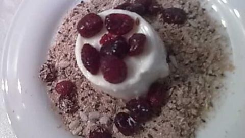 Ein cremiger Joghurt mit frischen Beeren liegt auf einer Schicht aus köstlichem Müsli, perfekt für Kalorien- und Kohlenhydrate-Zähler.