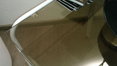 Die Autopolitur - ein Wundermittel für alles aus Glas. Ein gläserner Tisch glänzt nach der Anwendung von Autopolitur, umgeben von einem modernen Raum mit minimalistischem Design.