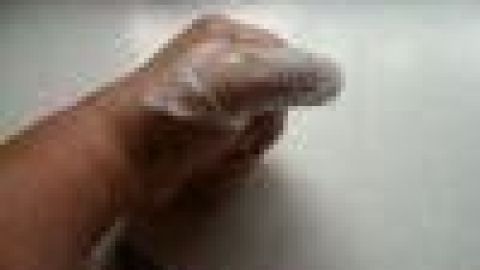 Ein Finger ist mit einem schnellen Verband umwickelt, während die Hand auf einer glatten Oberfläche ruht.
