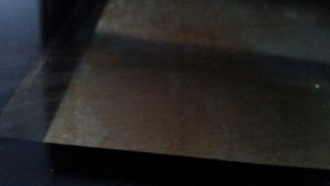 Ein glänzendes Ofenscheibe wird gereinigt, während ein Schmutzfilm entfernt wird, um Klarheit zu schaffen.