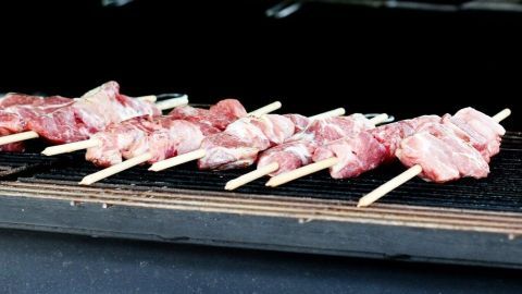 Schaschlikspieße liegen auf einem Grillrost und sind bereit zum Grillen, um saftige, gegrillte Leckerbissen zu werden.