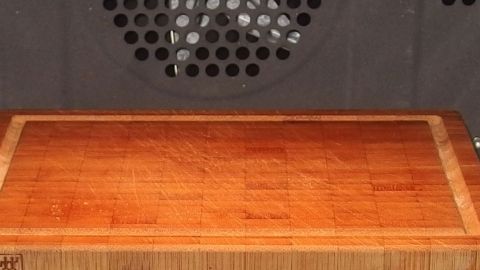 Ein Holzschneidebrett liegt sauber auf einer Arbeitsfläche und ist bereit zum Schneiden in einer modernen Küche.