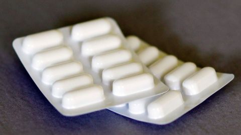 Die Packung mit weißen Tabletten liegt auf einem dunklen Hintergrund und könnte helfen, Juckreiz bei Penicillin-Allergie zu lindern.