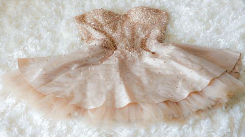 Ein zartes, funkelndes Kleid liegt auf einem weichen, weißen Untergrund und wartet darauf, aufgefrischt zu werden.
