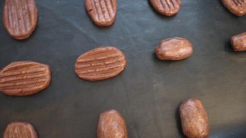 Die Schoko-Chili-Plätzchen liegen frisch auf einem Backblech, bereit zum Backen in einer warmen Küche.