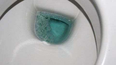 Eine Schaumwolke aus Mundspülwasser befindet sich im Toilettenbecken, um die schmutzige Toilette zu reinigen.