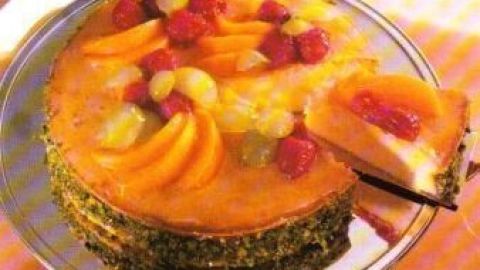 Ein Käsekuchen mit fruchtigem Belag wird serviert, während ein Stück davon auf einem Teller steht, um genossen zu werden.
