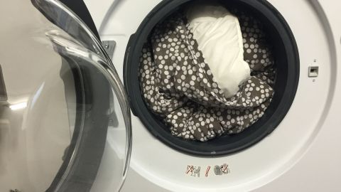 Eine Waschmaschine zeigt Bettwäsche, die gewaschen wird, um die Sauberkeit und Frische für ganz bequeme Leute zu gewährleisten.