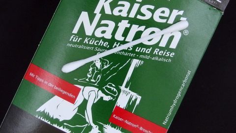 Eine Packung Kaiser Natron liegt auf schwarzem Untergrund, bereit zur Anwendung in Küche, Gesundheit und Reisen.